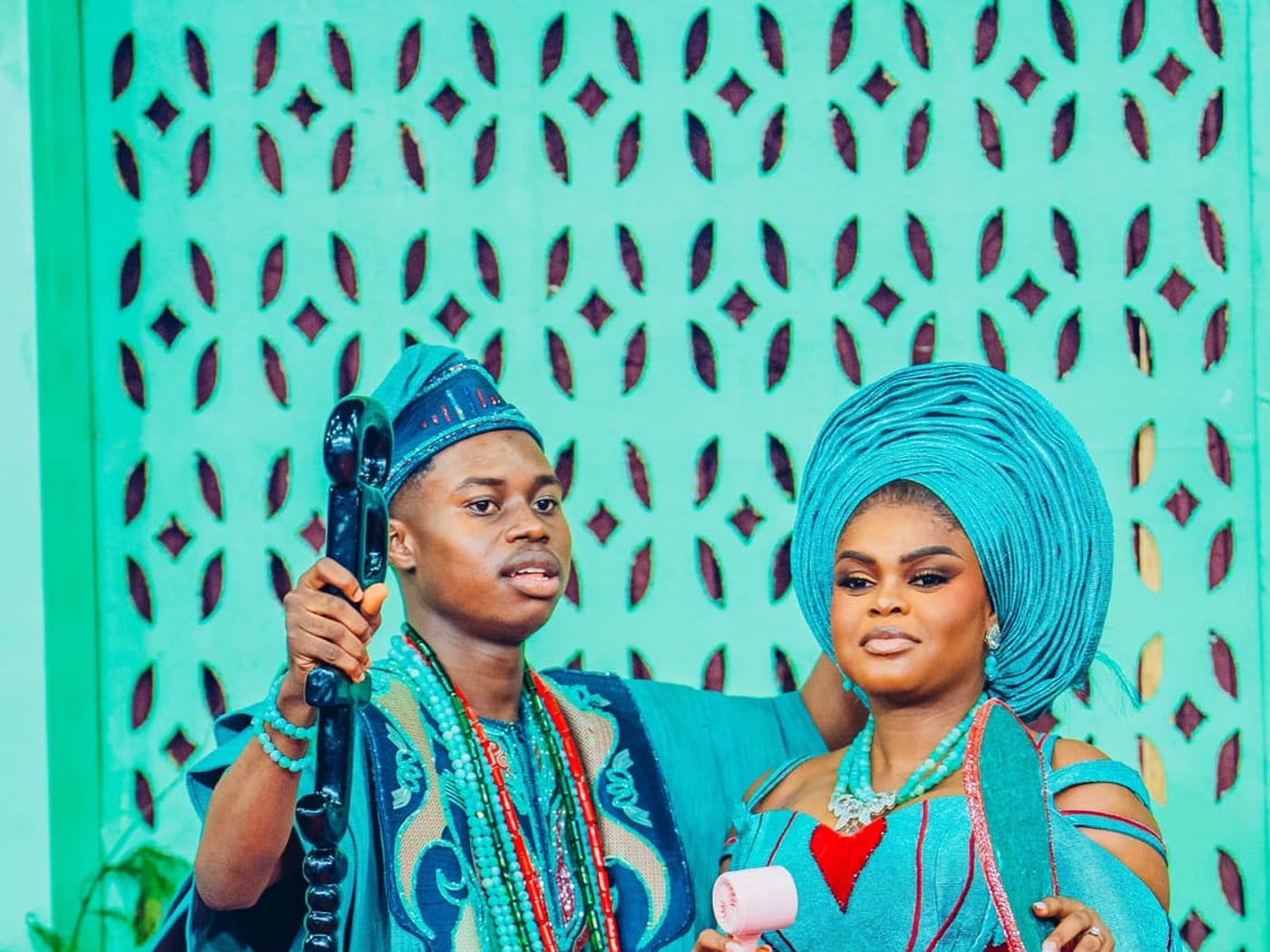 A couple in matching teal on stage at the wedding party of Peller and Jarvis.